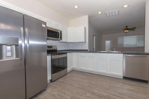 a kitchen with stainless steel appliances and white cabinets