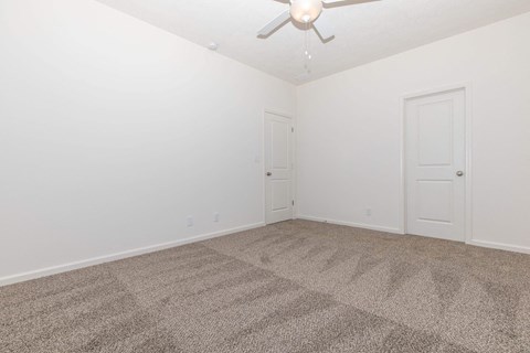 a empty room with carpet and a ceiling fan