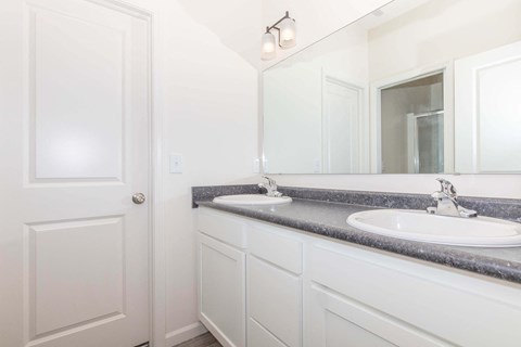 a white bathroom with two sinks and a mirror