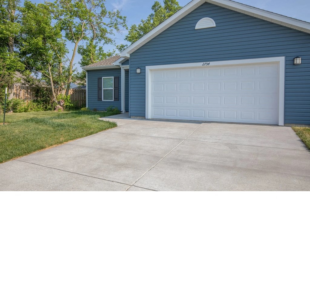 a white garage door on a blue house with a driveway