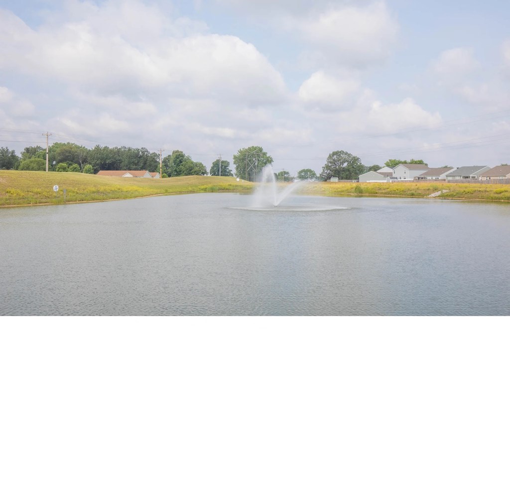 a pond with a water fountain in the middle of it