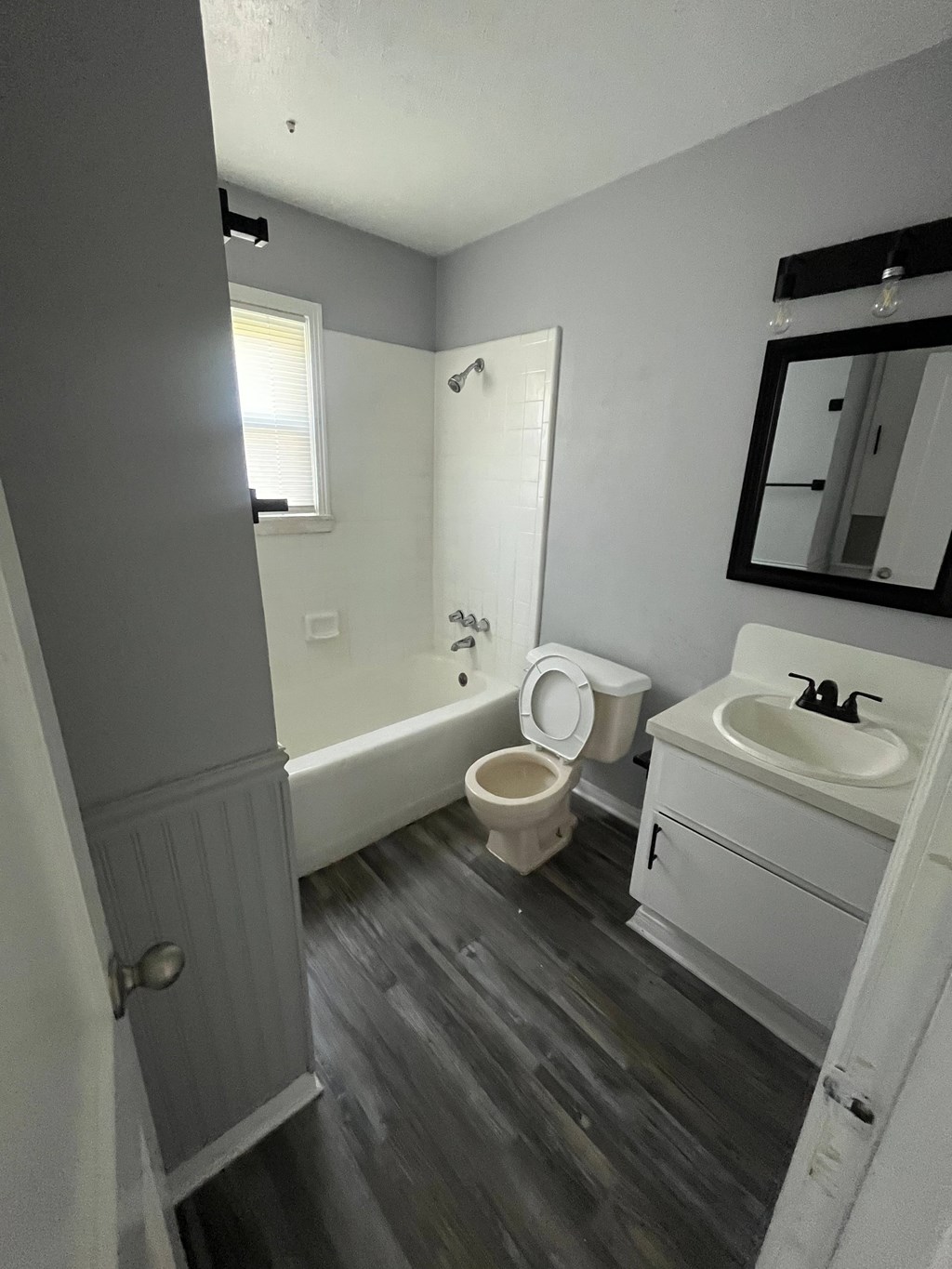 A bathroom with a toilet, sink, and bathtub.
