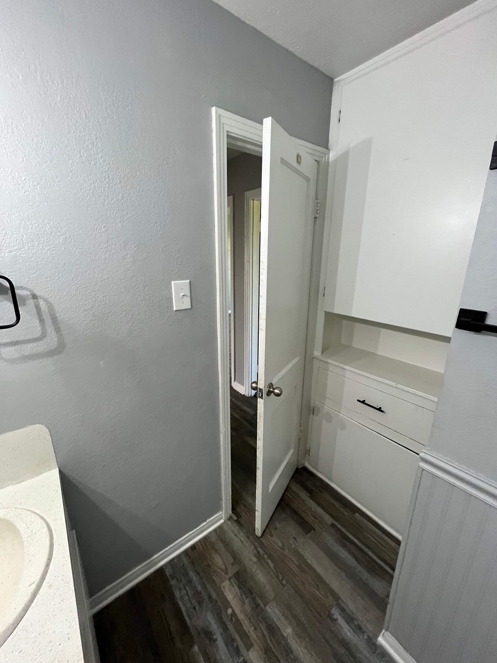 A bathroom with a white sink and a white cabinet.