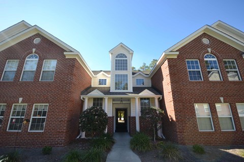 the front entrance of a brick building with a walkway