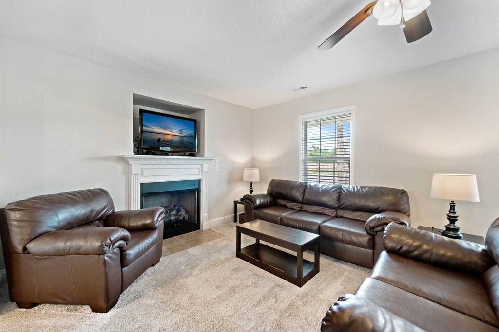 a living room with leather couches and a fireplace