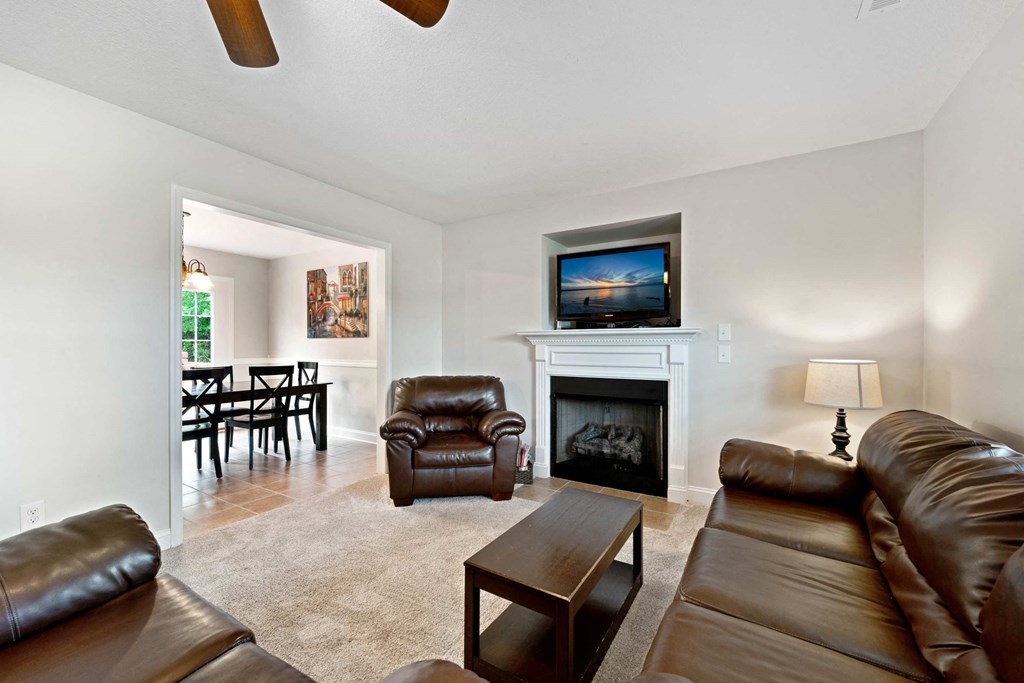 a living room with leather furniture and a fireplace