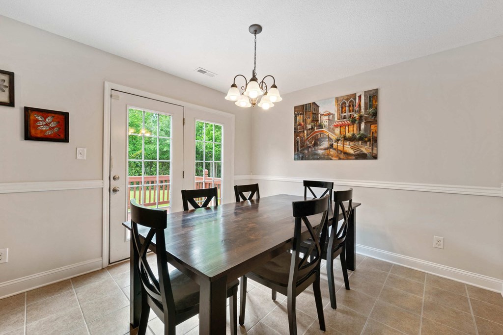 a dining room with a wooden table and chairs