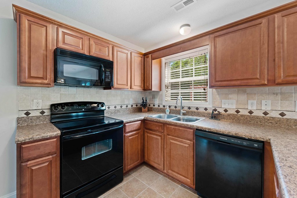 a kitchen with black appliances and wooden cabinets