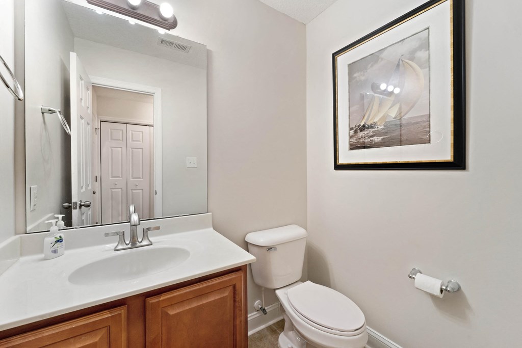 a bathroom with a mirror and a toilet and a sink