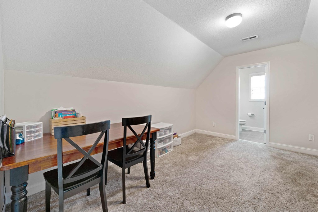 a living room with a dining room table and chairs