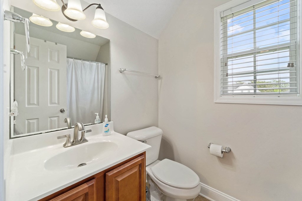 a bathroom with a sink toilet and a mirror