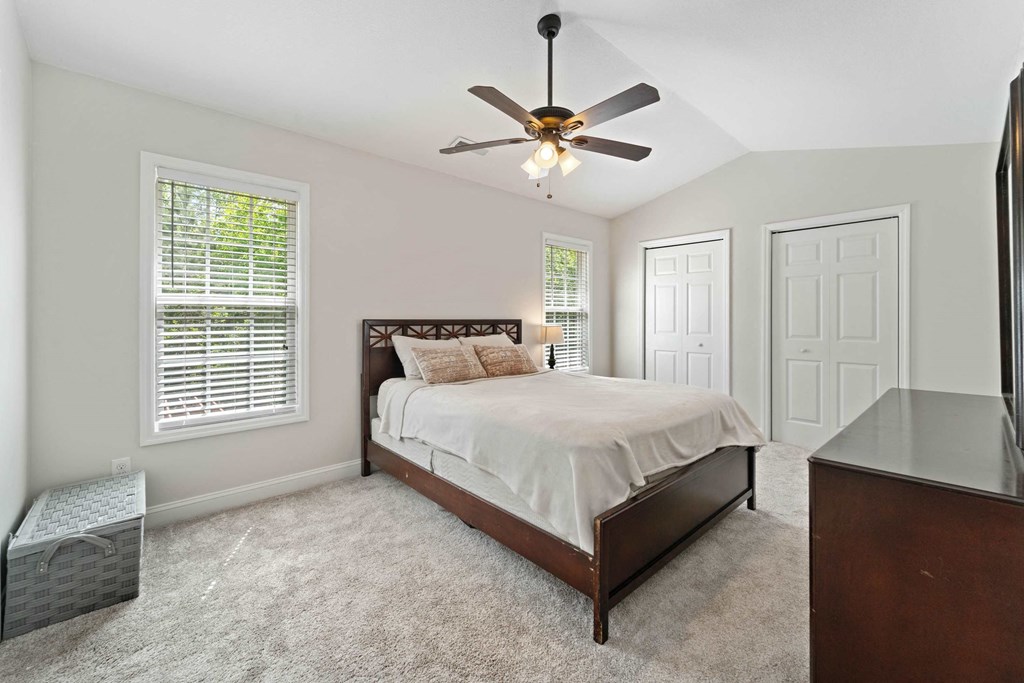 a bedroom with a bed and a ceiling fan