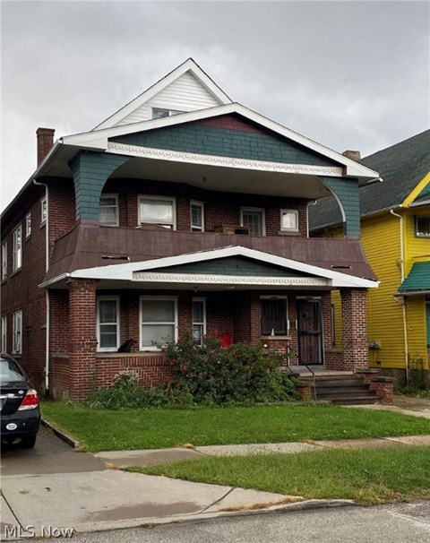 a brick house with a green roof on a street