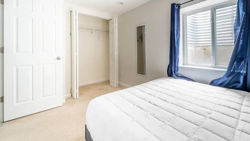 a bedroom with a bed and a closet and a window