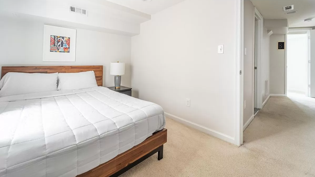 a bedroom with a large white bed and a hallway