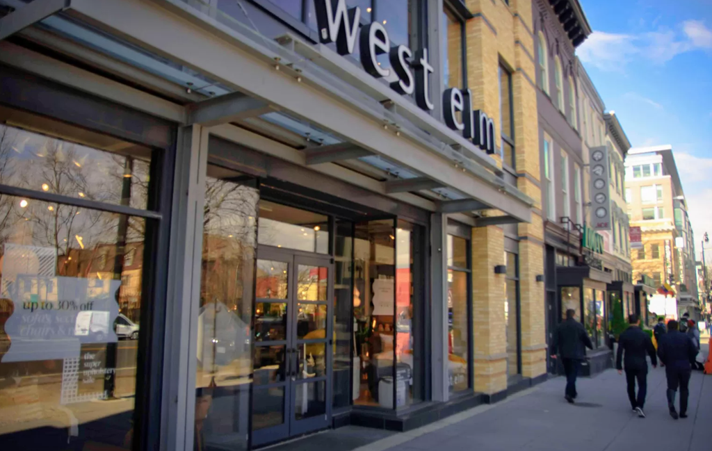 pedestrians walk past the entrance to the west end of a store
