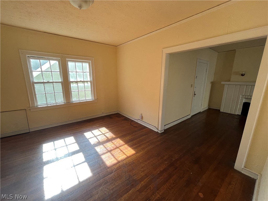 an empty living room with wooden floors and a window