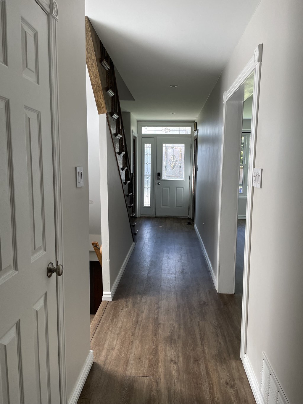 a look down the hallway of a home with a staircase