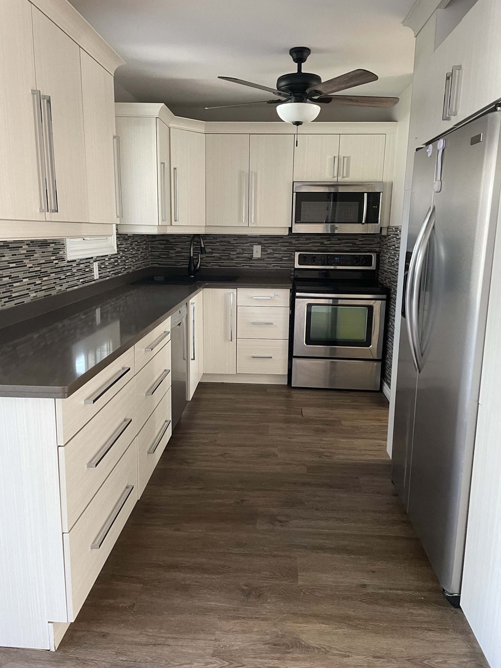 a kitchen with white cabinets and stainless steel appliances