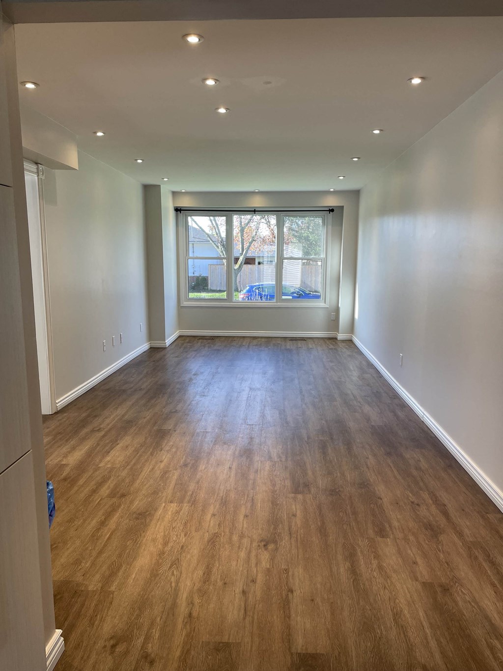 a living room with a large window and wooden floors