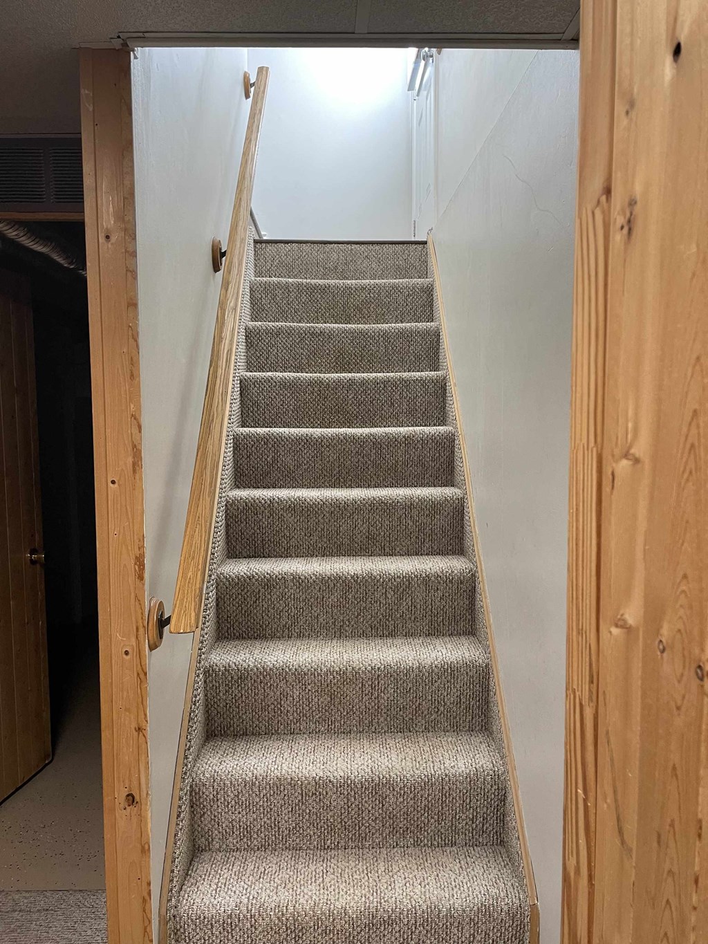 a set of stairs with carpeted stairs in a room with a wooden door