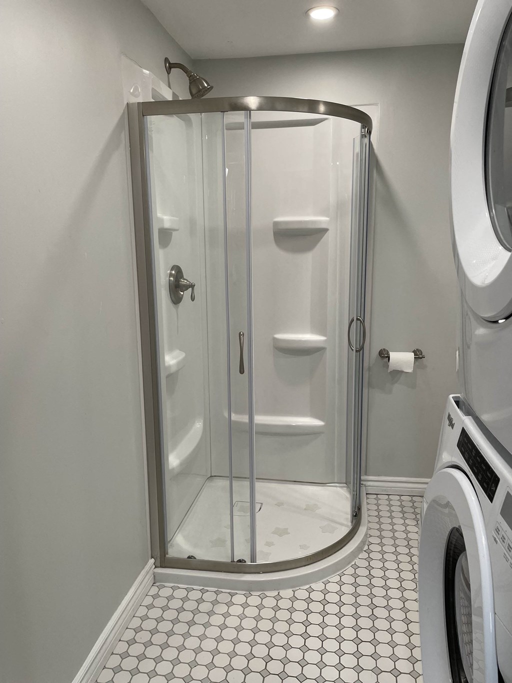 a small bathroom with a shower and a washing machine