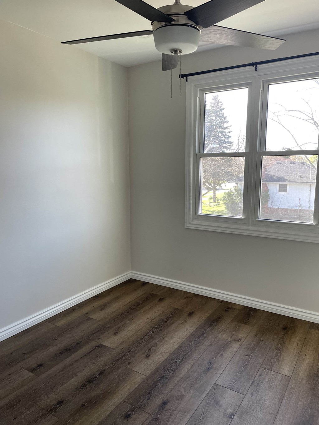 an empty room with a ceiling fan and a window