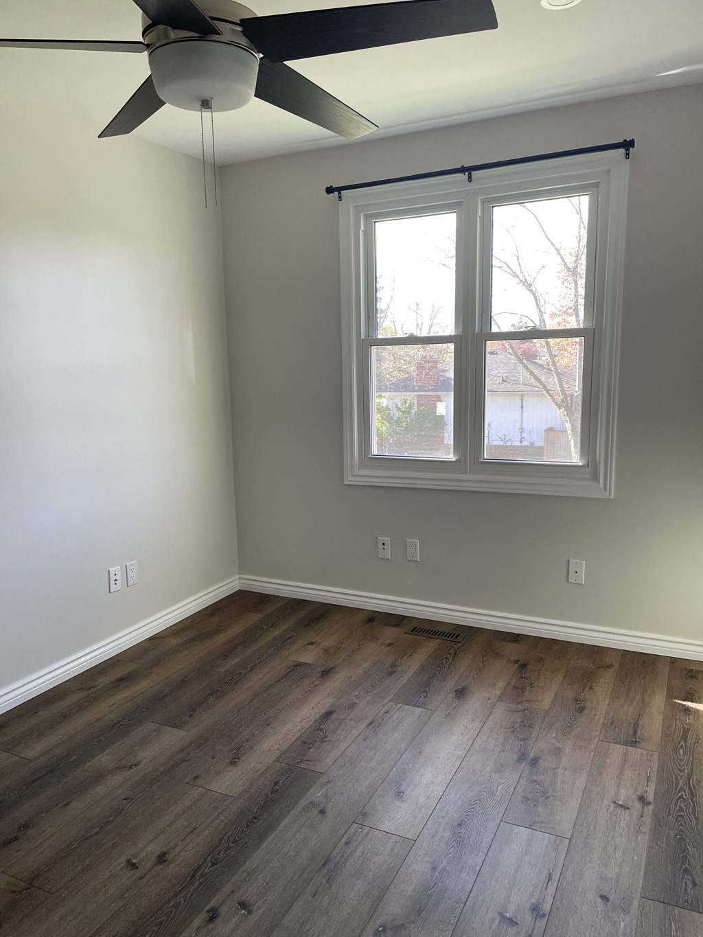 a living room with wood floors and a window