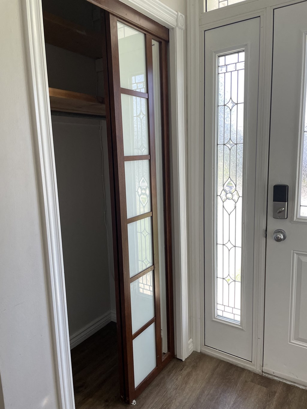 the door to the closet is open to the hallway with a mirror and a door