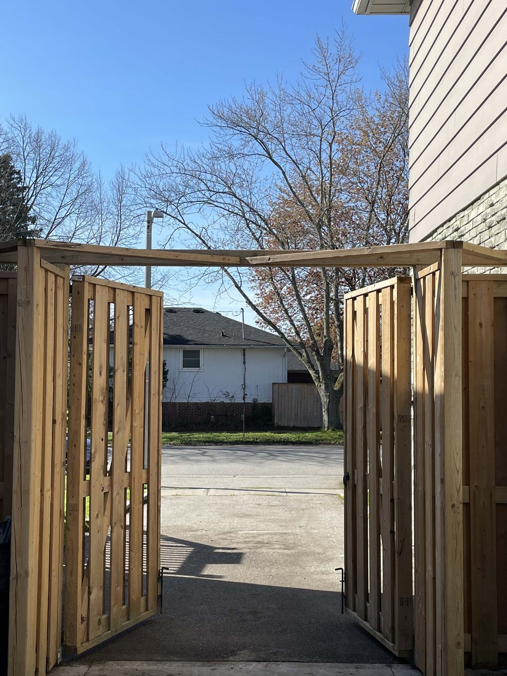 a backyard with a wooden gate and a house