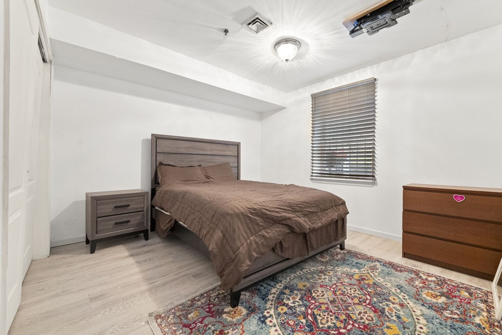 a bedroom with a bed and a dresser and a window