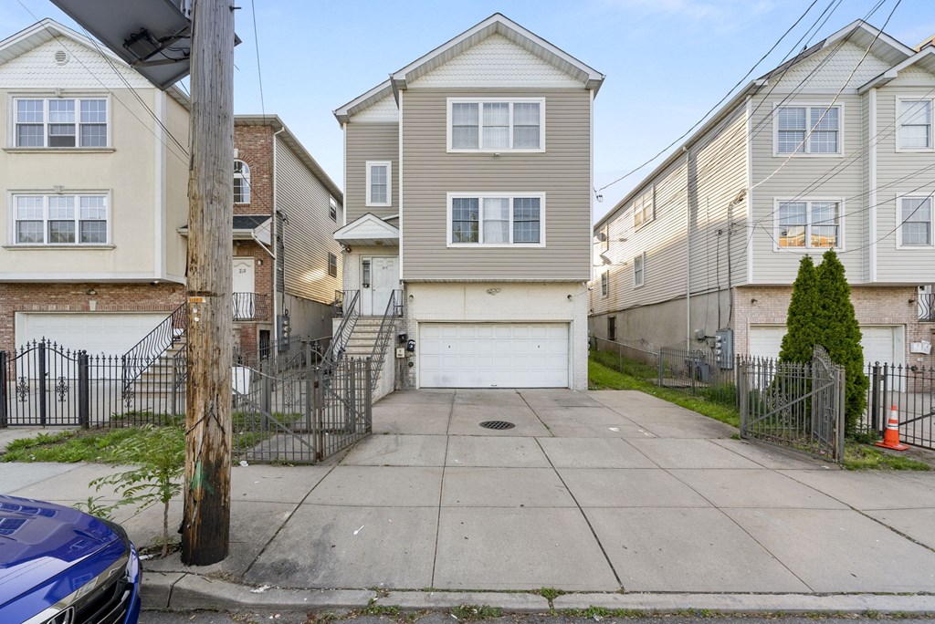 the driveway of an apartment building with a white garage door