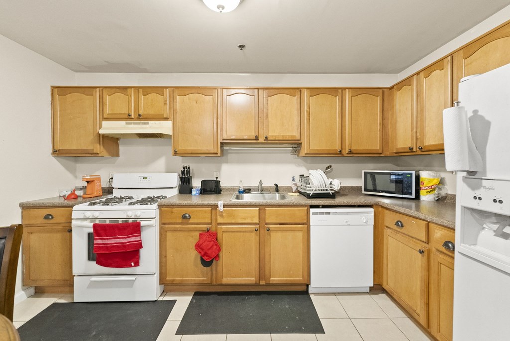 a kitchen with white appliances and wooden cabinets