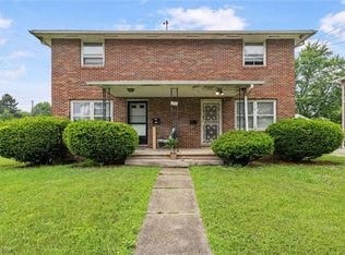 A brick house with a white door and windows.