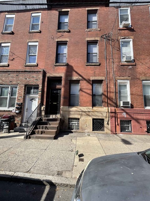 A red brick building with a black door and a white door.