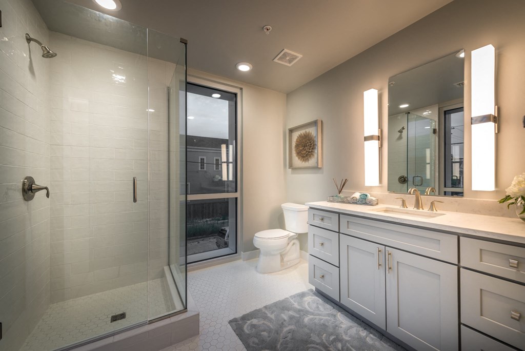 a bathroom with a shower and a sink and a toilet