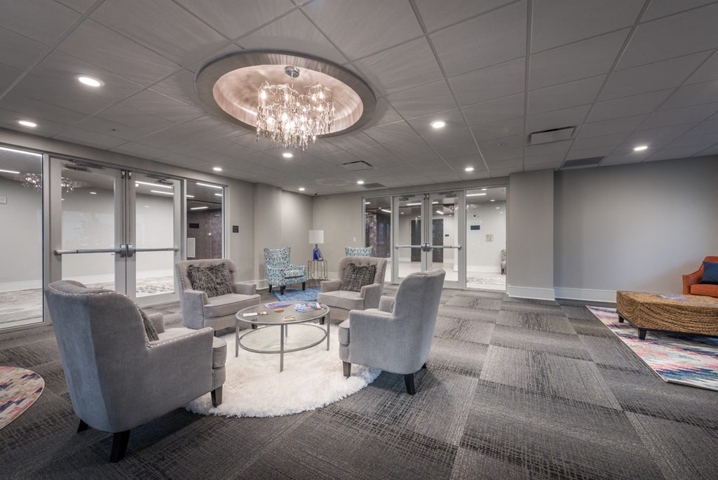 a lobby with couches chairs and tables and a chandelier