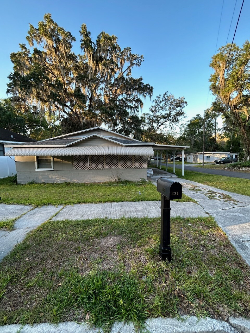 a parking meter in the grass in front of a house