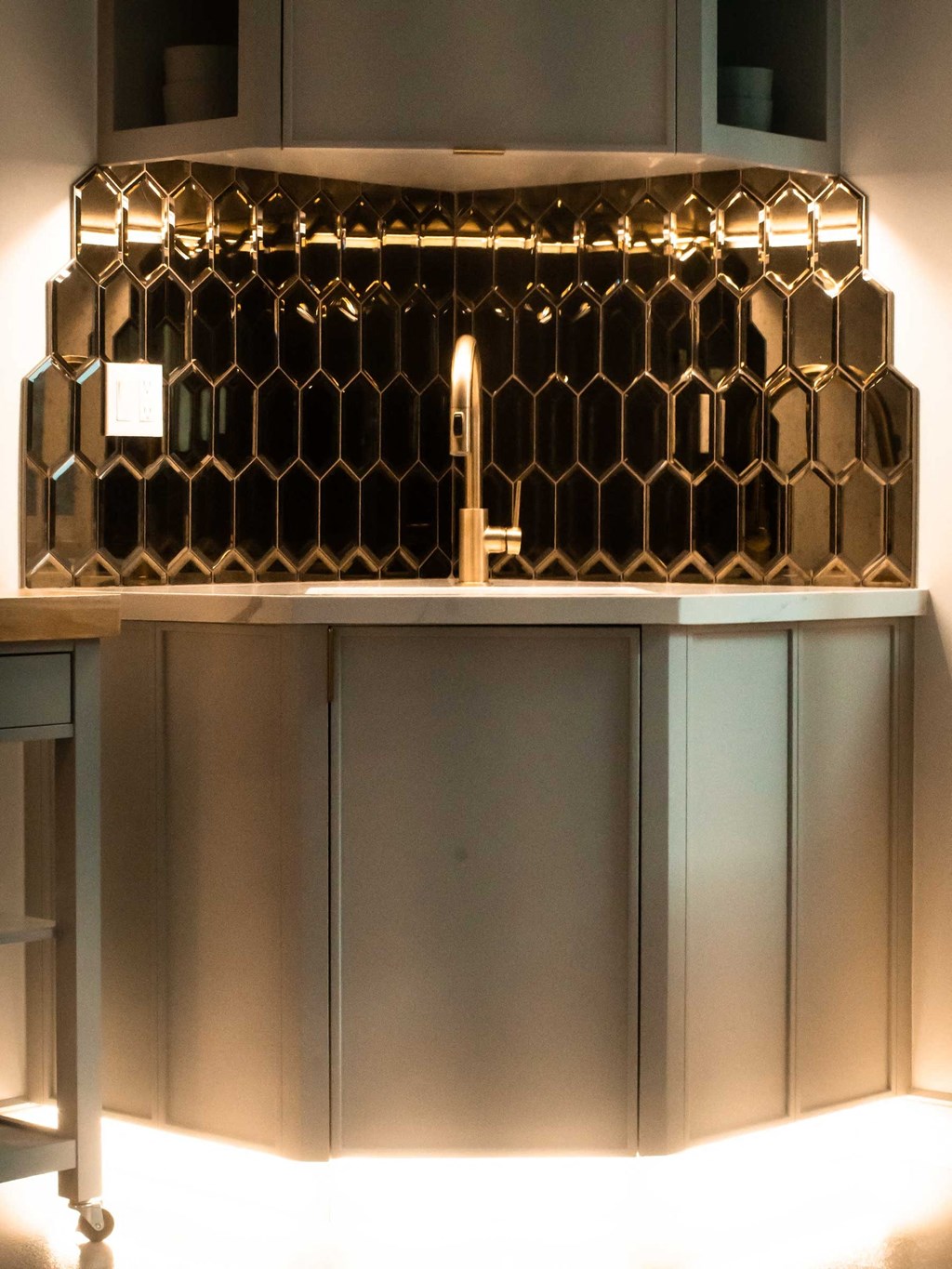 a kitchen with a counter top with a sink and a mirror