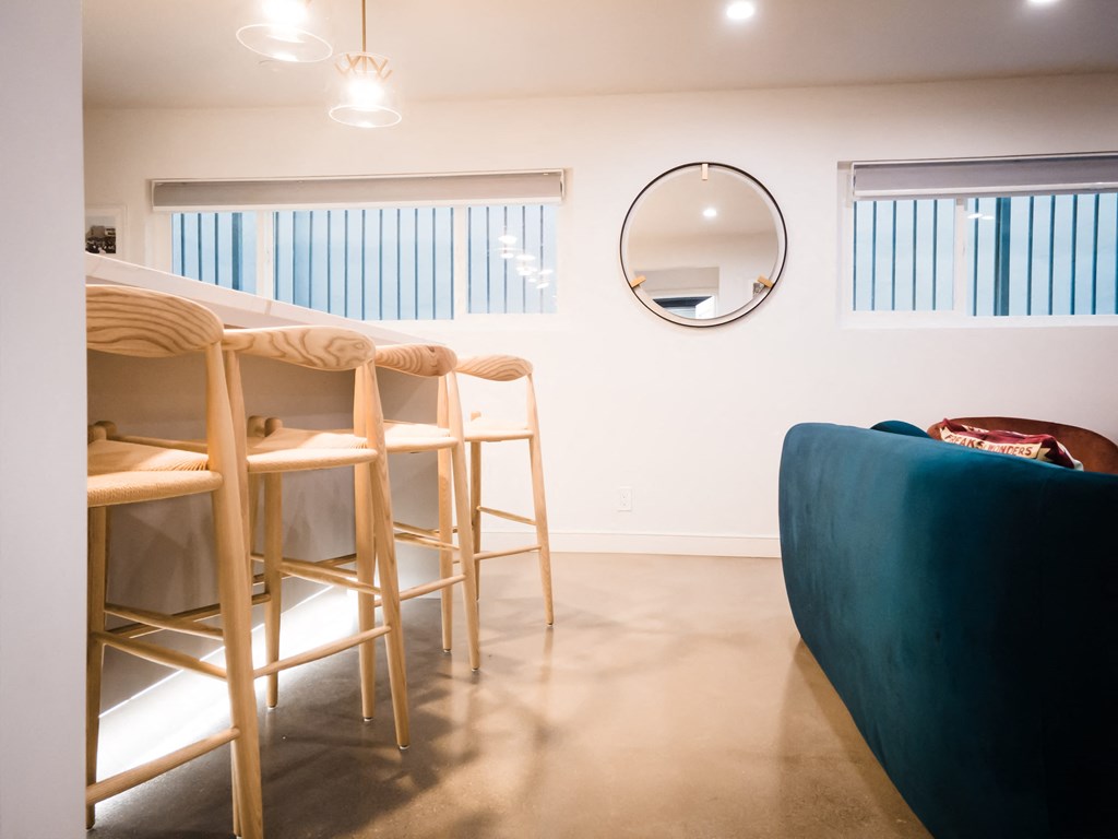 a dining room with a table and chairs and a mirror