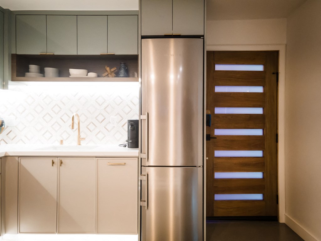 a kitchen with white cabinets and a stainless steel refrigerator