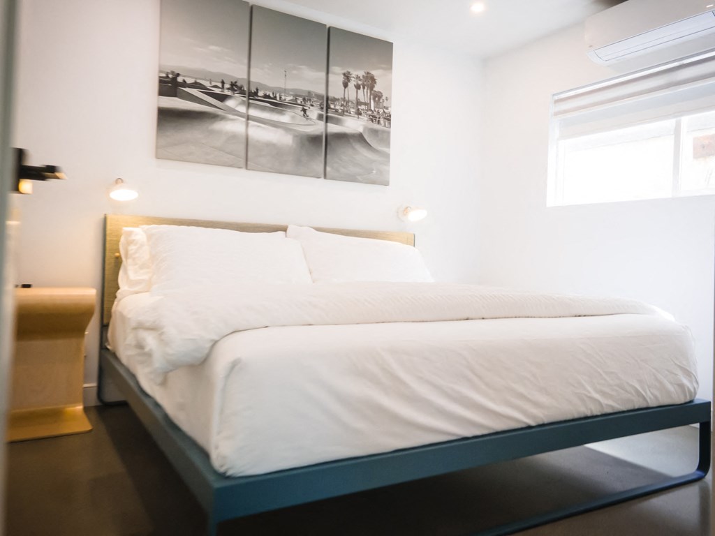 a bedroom with a bed and a painting on the wall