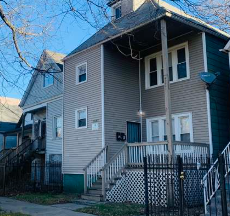 a house with a white porch and a fence