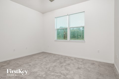 the living room of a home with carpet and a window
