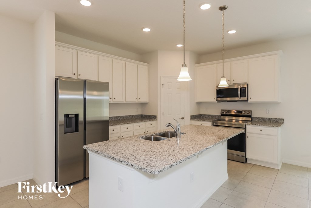 a kitchen with white cabinets and a granite counter top