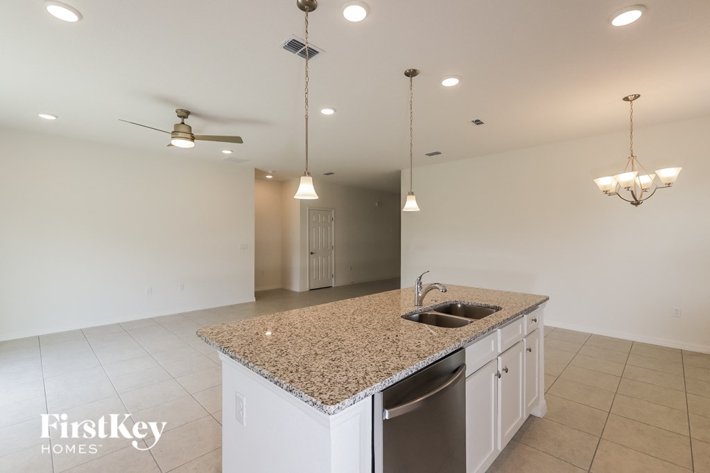 a kitchen with white cabinets and granite counter tops and a sink
