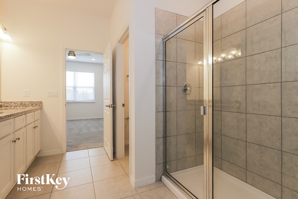 a bathroom with a shower and a sink and a closet