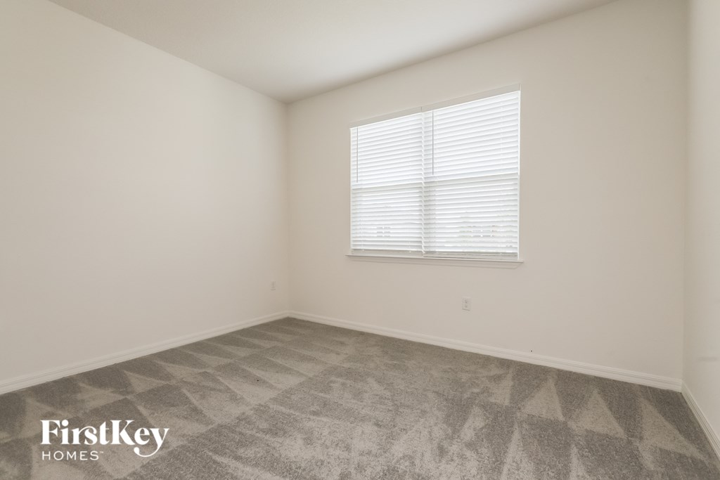 the living room of an apartment with white walls and a window