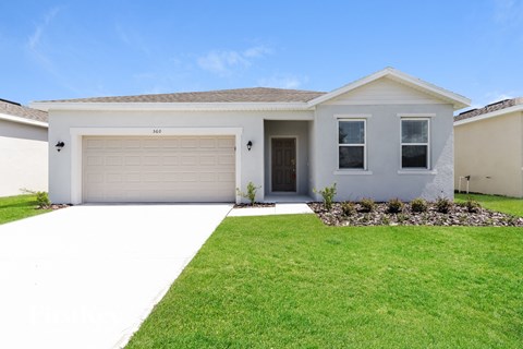 A white house with a garage door and windows.