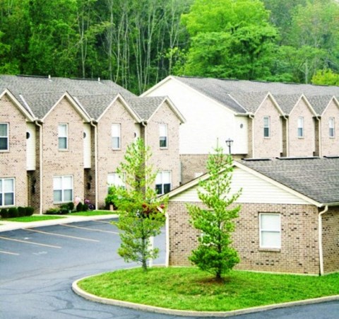 an empty parking lot in front of a row of houses